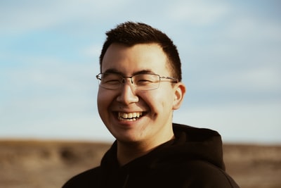 Smile of a man dressed in a black jumper hoodies
